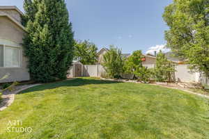 Spacious lawn bordered by a paved walkway and mature trees
