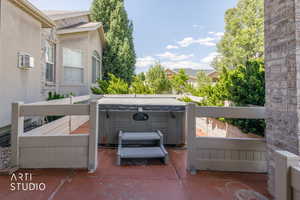 Outdoor spa with protective fencing situated on a red-toned patio