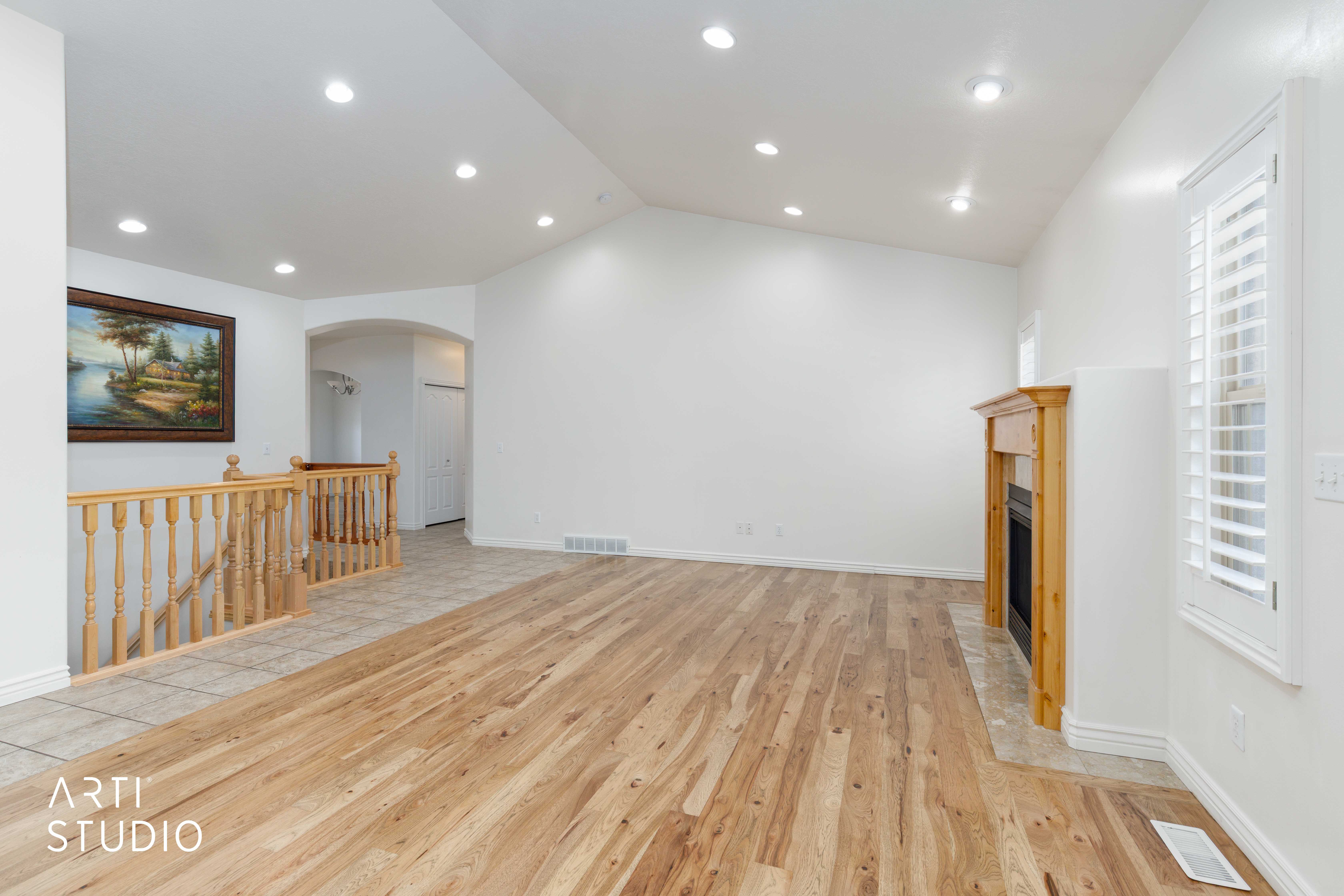 Spacious living area featuring wood-finish flooring, a fireplace with a wood mantle, recessed lighting, and white plantation shutters