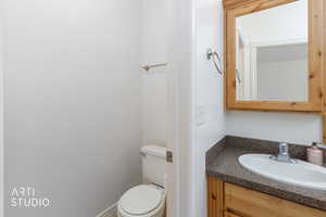 Bathroom vanity with a wood-finish cabinet, speckled countertop, and integrated sink