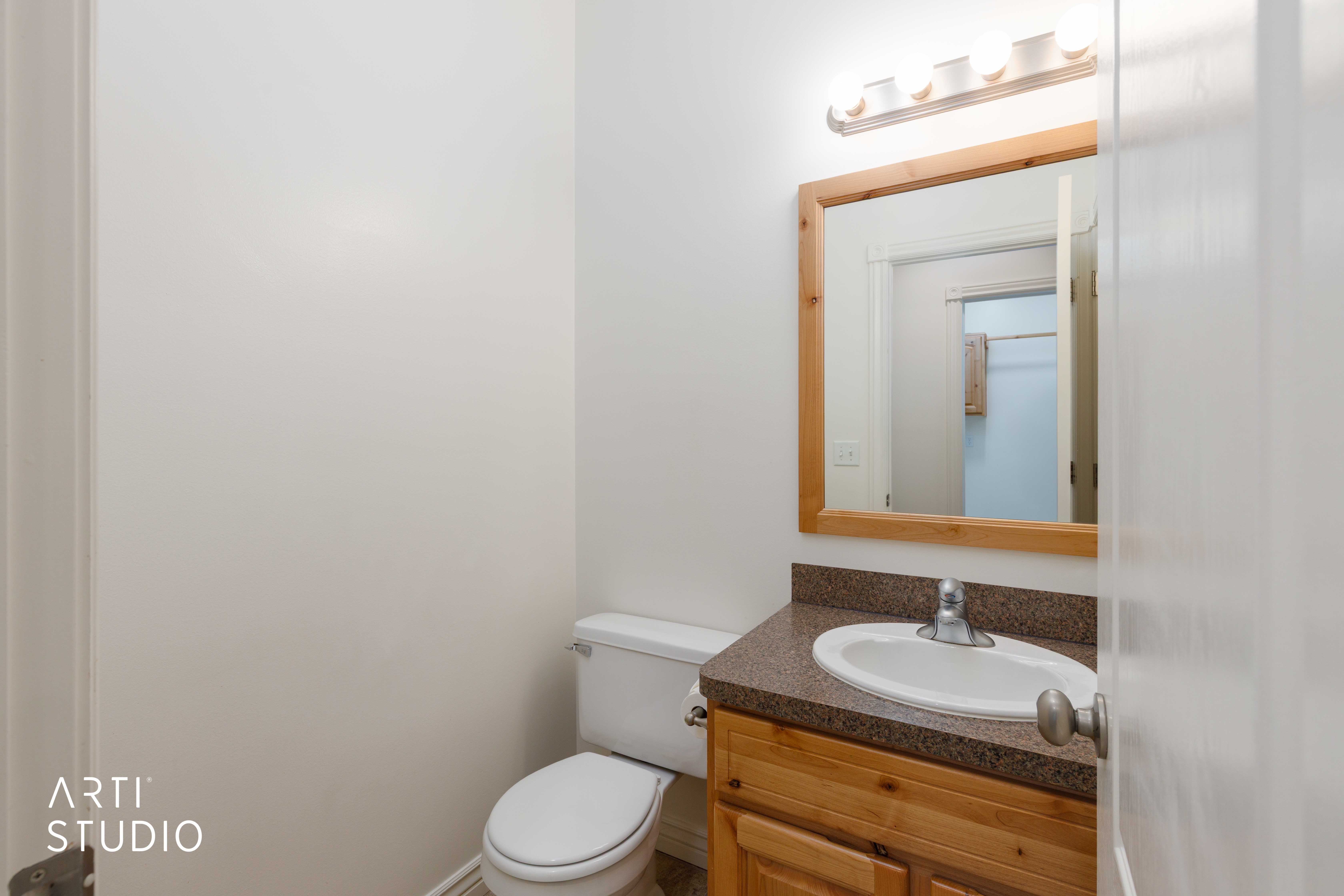 Bathroom featuring a wood-finish vanity with an integrated sink and a speckled countertop