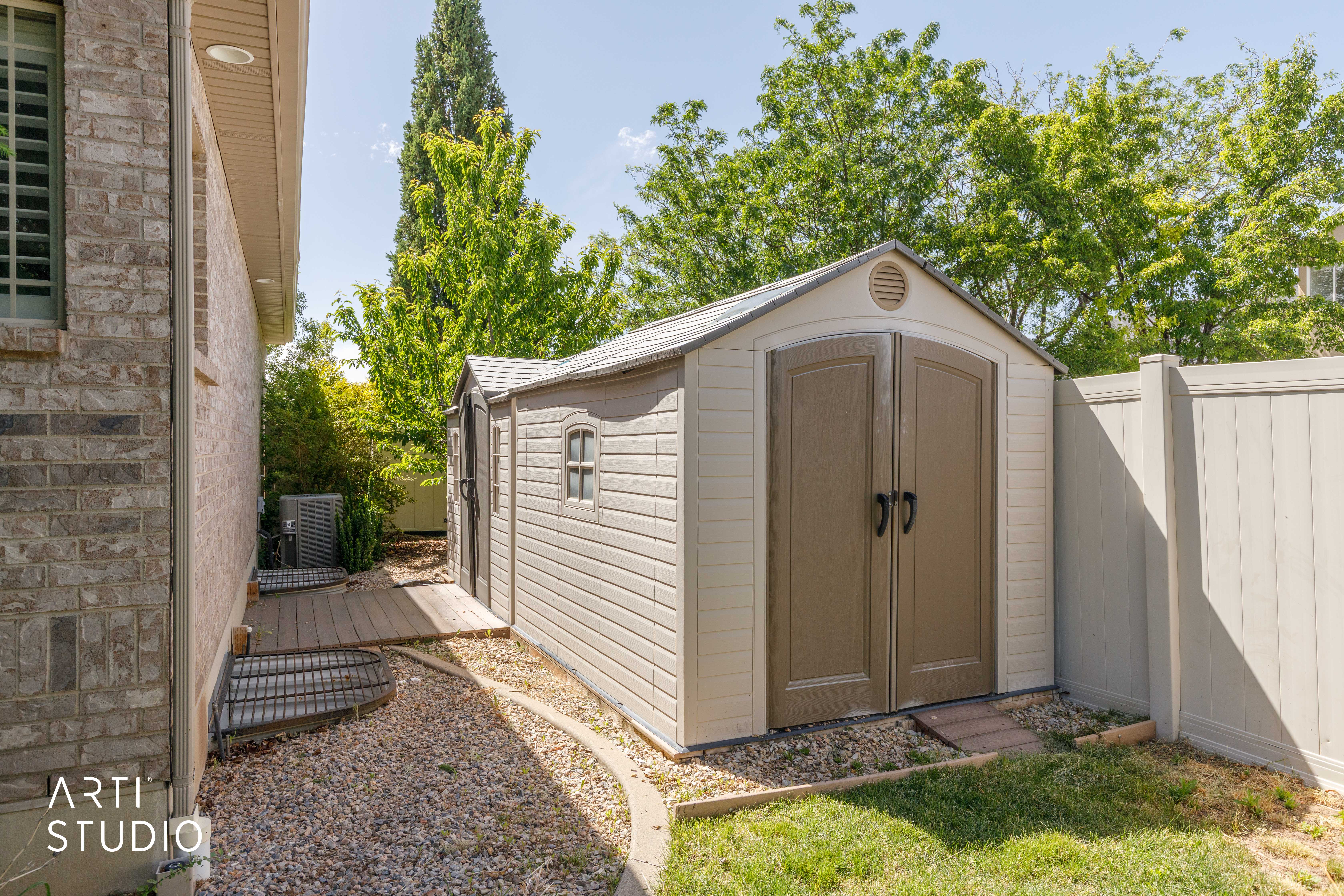 Outdoor storage shed featuring double doors and a gable roof
