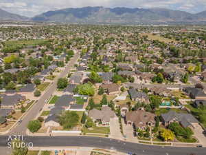Expansive residential area with a mountain backdrop, featuring numerous single-family homes, mature trees, paved streets, and a mixture of residential and undeveloped land