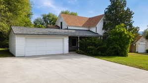 Concrete driveway leading to an attached two-car garage with white panel doors
