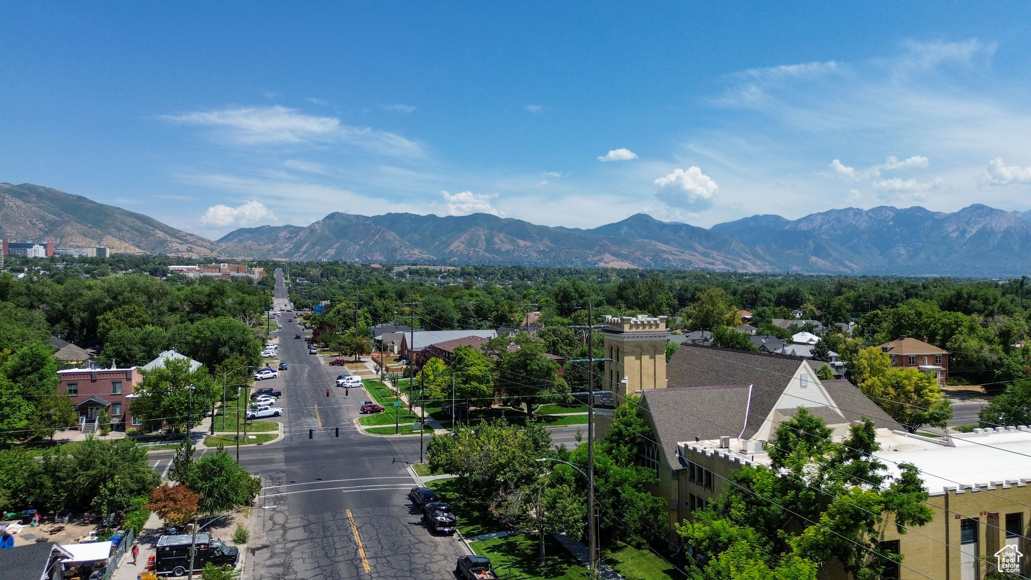 Expansive neighborhood featuring mature trees and distant mountain ranges