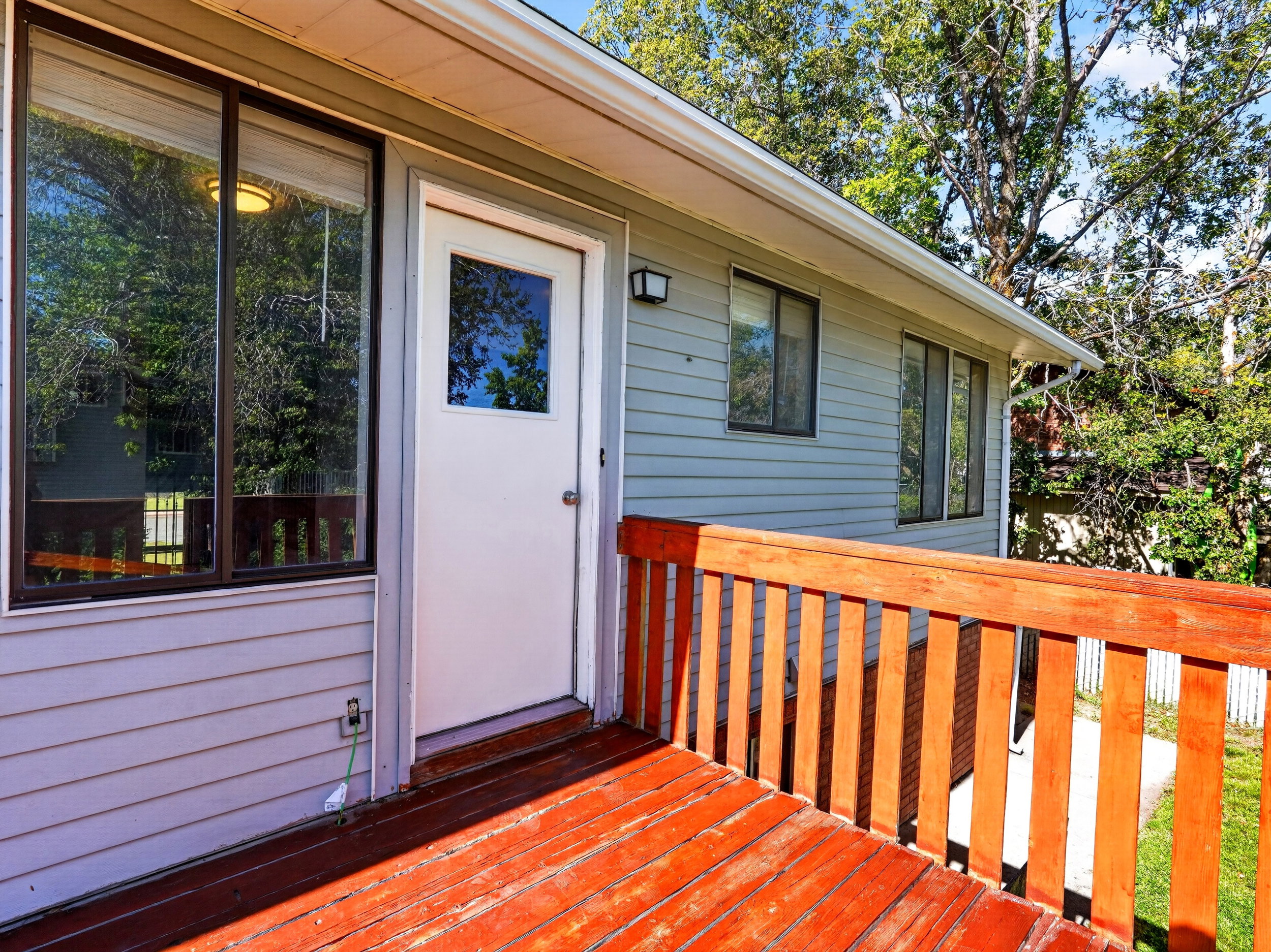 Outdoor deck featuring wood railing and red-stained wood-finish flooring