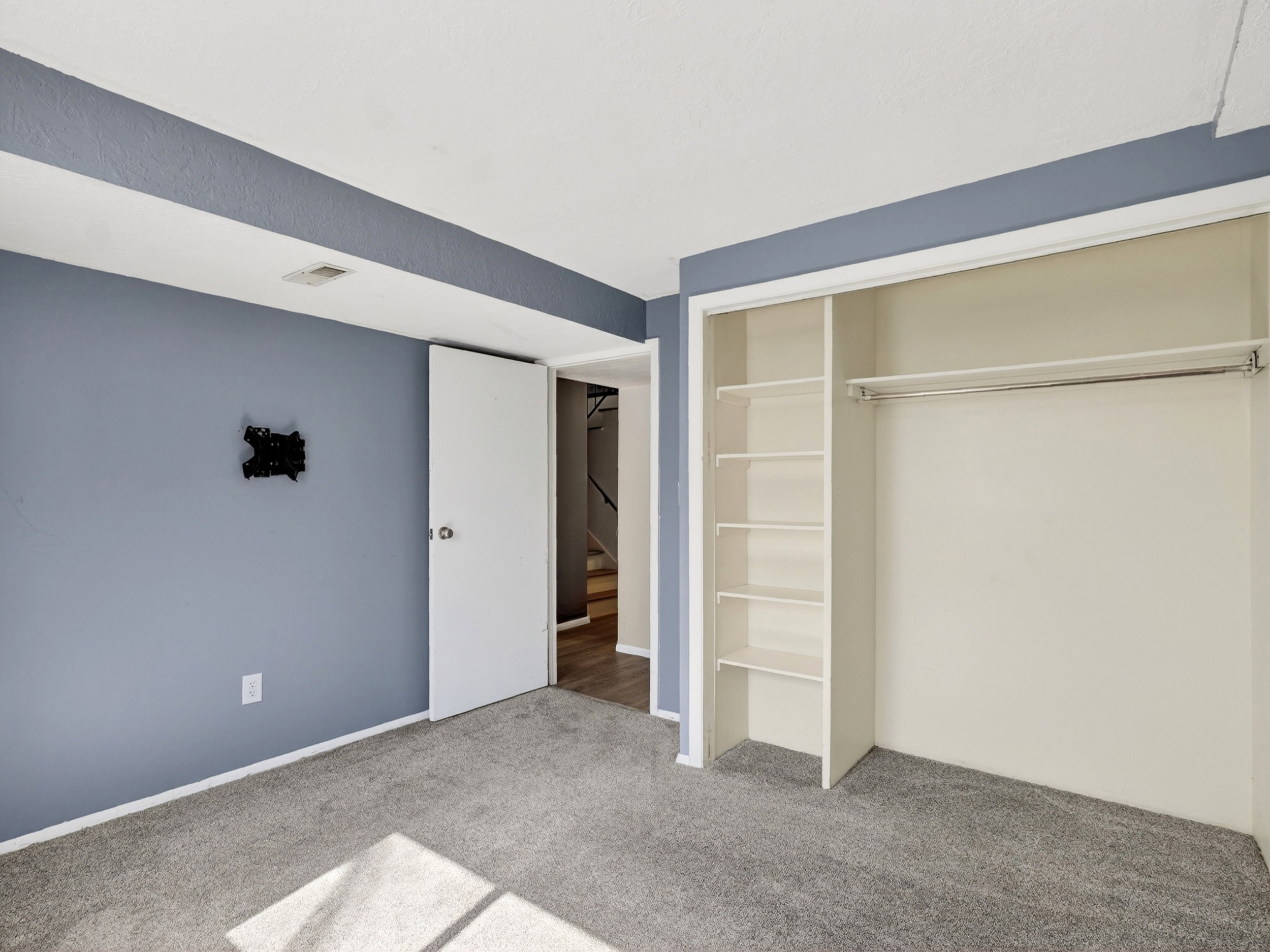 Bedroom featuring gray carpet flooring, blue painted walls, and white trim