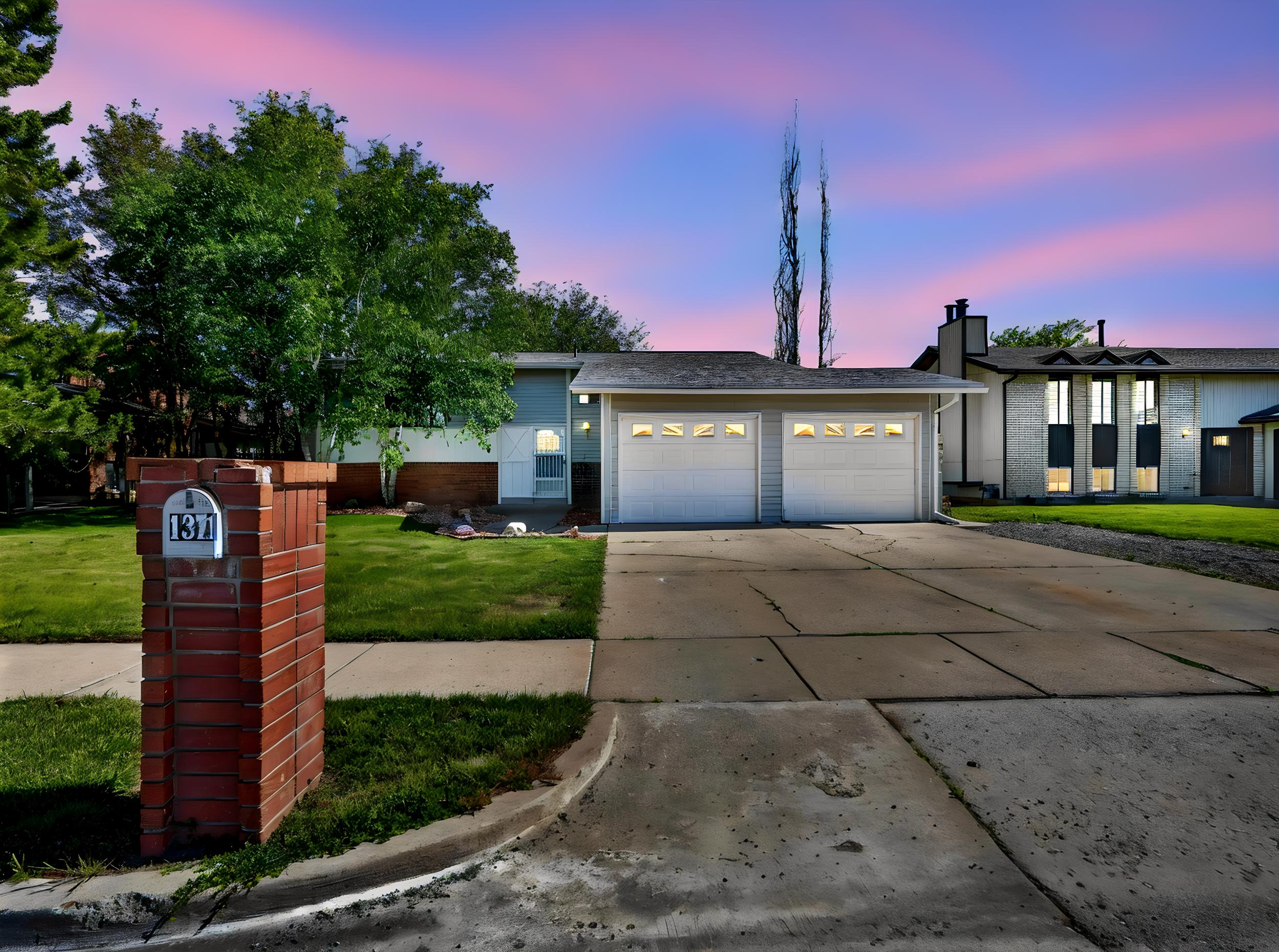 Light blue siding exterior with a two-car garage featuring individual doors