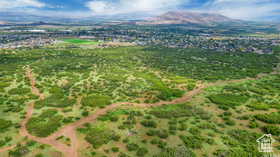 Expansive open terrain featuring natural vegetation and visible dirt paths