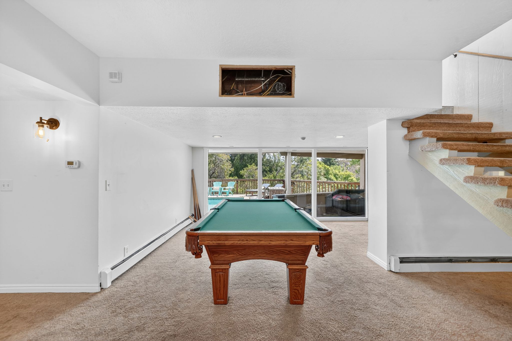 Recreation room with full-height sliding glass doors opening to outdoor living spaces