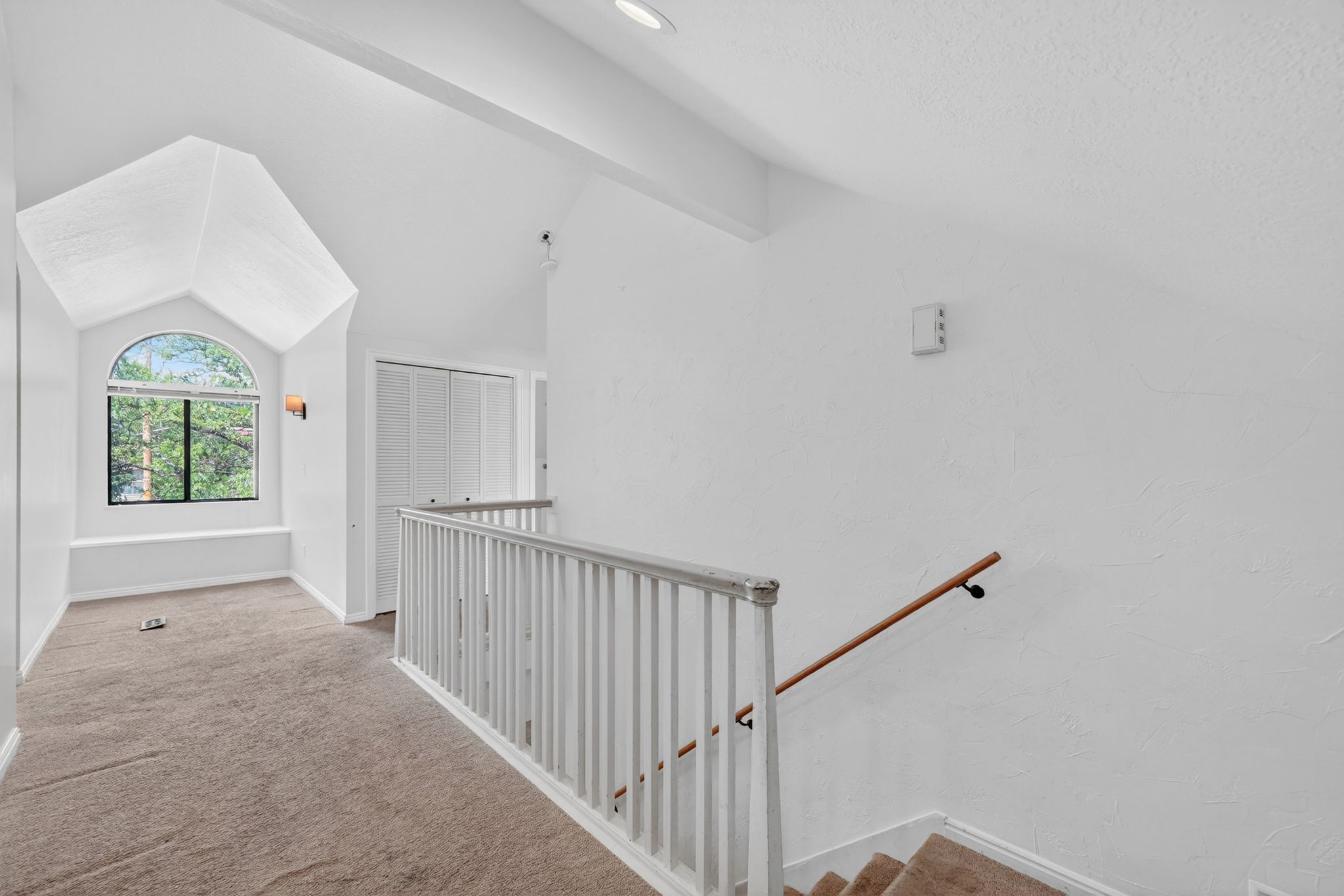 Vaulted ceiling with an arched window and built-in window seat