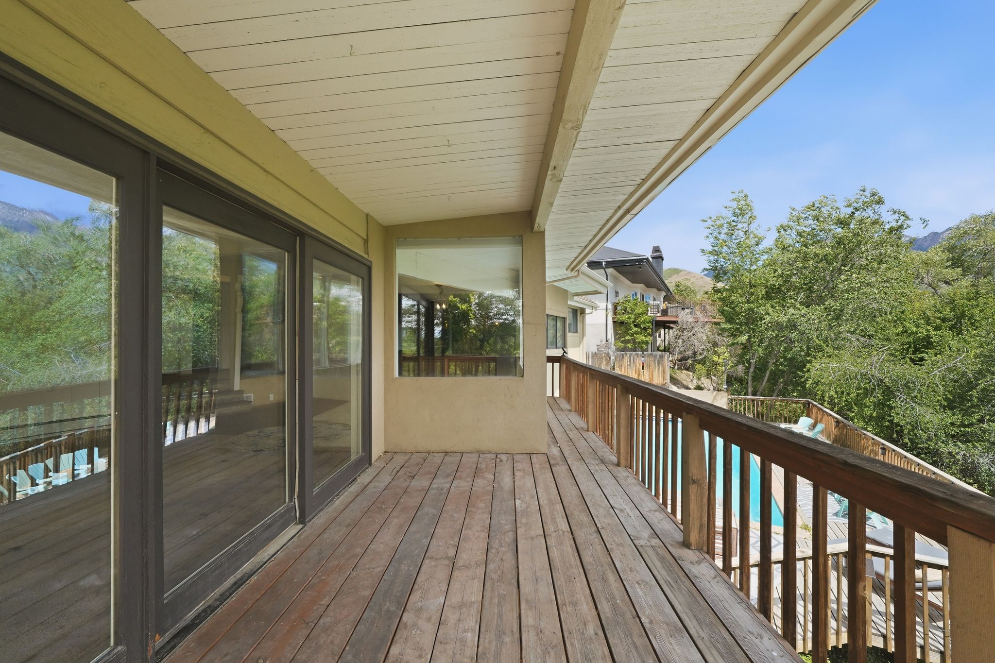 Expansive outdoor deck featuring wood-finish flooring, a wood railing, and a covered ceiling