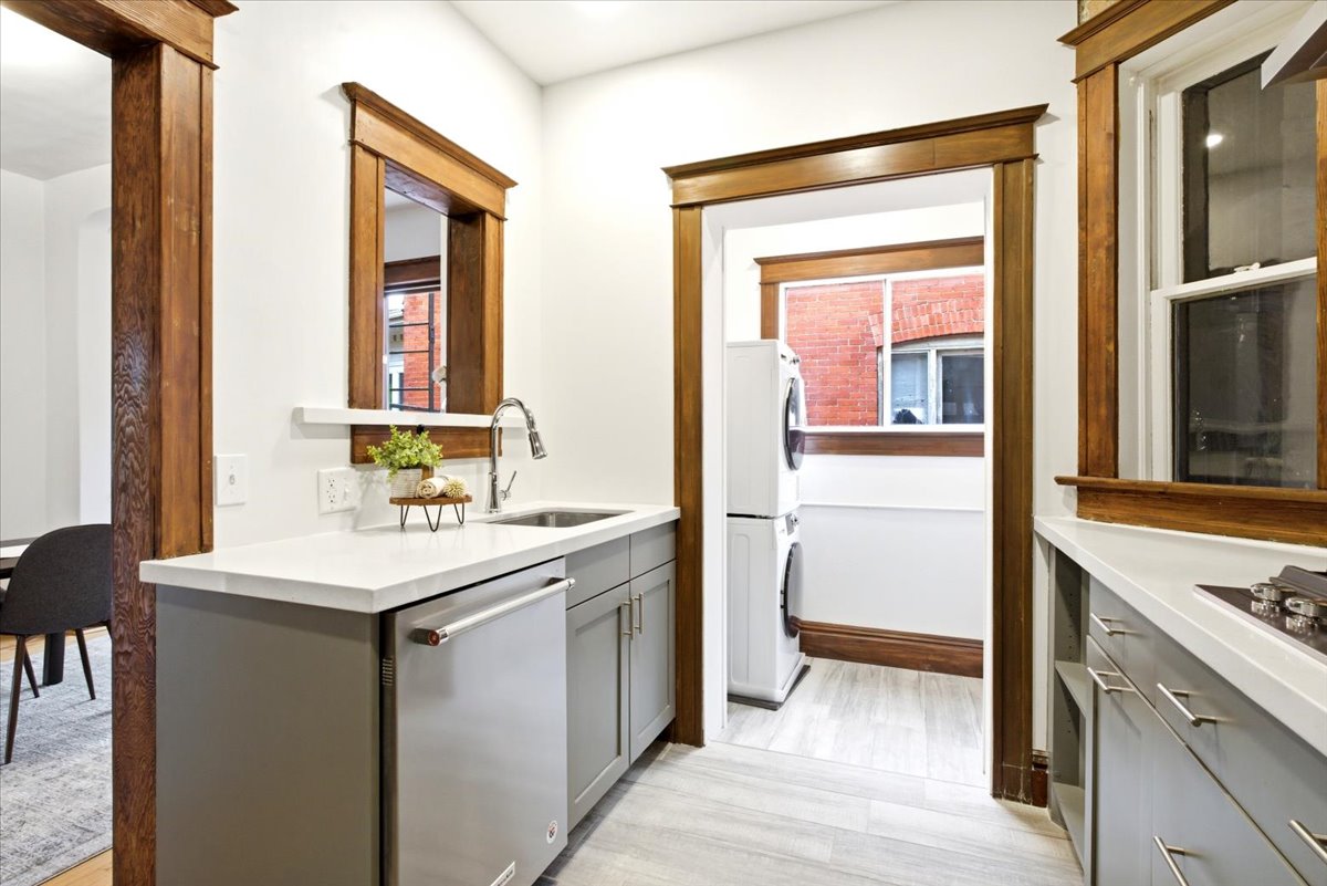 Utility space featuring light wood-finish flooring, white countertops, and gray cabinetry
