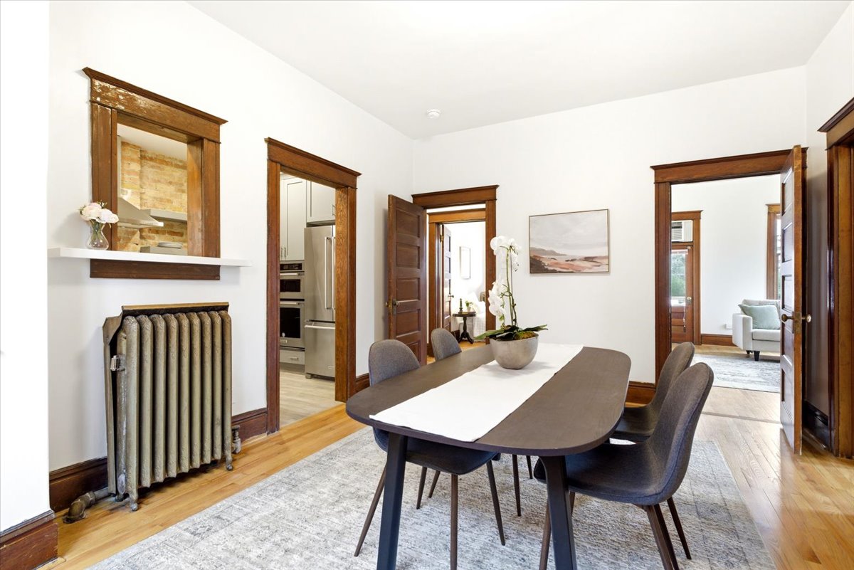 Dining area featuring wood-finish flooring and white walls