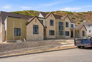 Stone and stucco facade residence featuring multiple gables and a covered entry