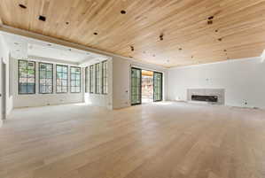 Expansive room featuring wood-finish flooring and a wood plank ceiling with recessed lighting