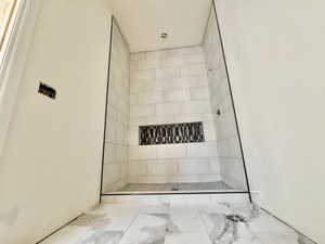 Shower enclosure featuring light-toned rectangular wall tiles and a mosaic tile accent niche