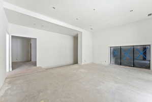 Spacious room with high ceilings, recessed lighting, and a large built-in niche featuring three panels