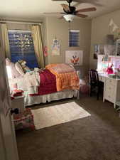 Bedroom featuring carpet flooring, a ceiling fan with integrated lighting, and a white window blind