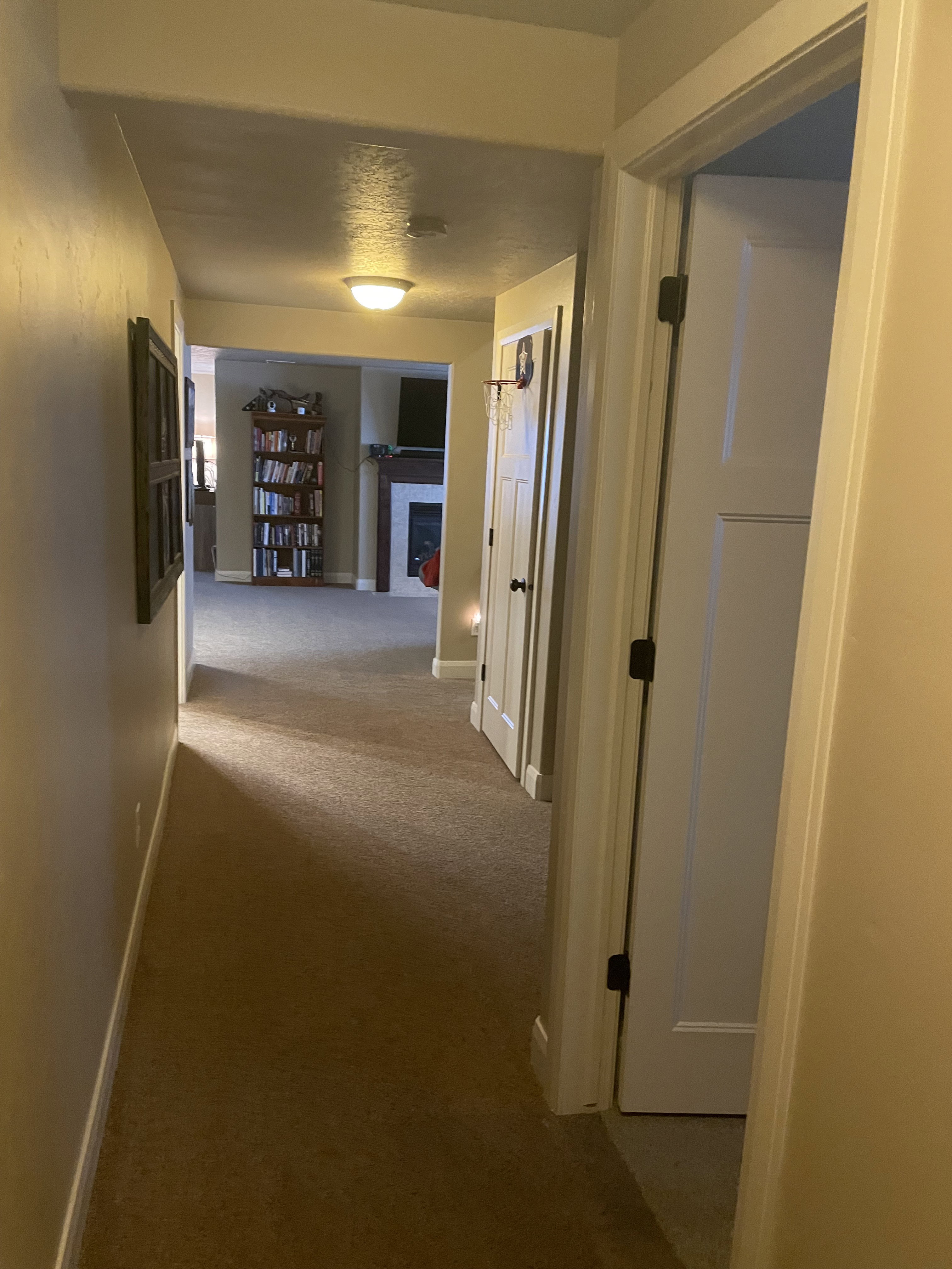 Hallway with carpet flooring and warm-toned walls