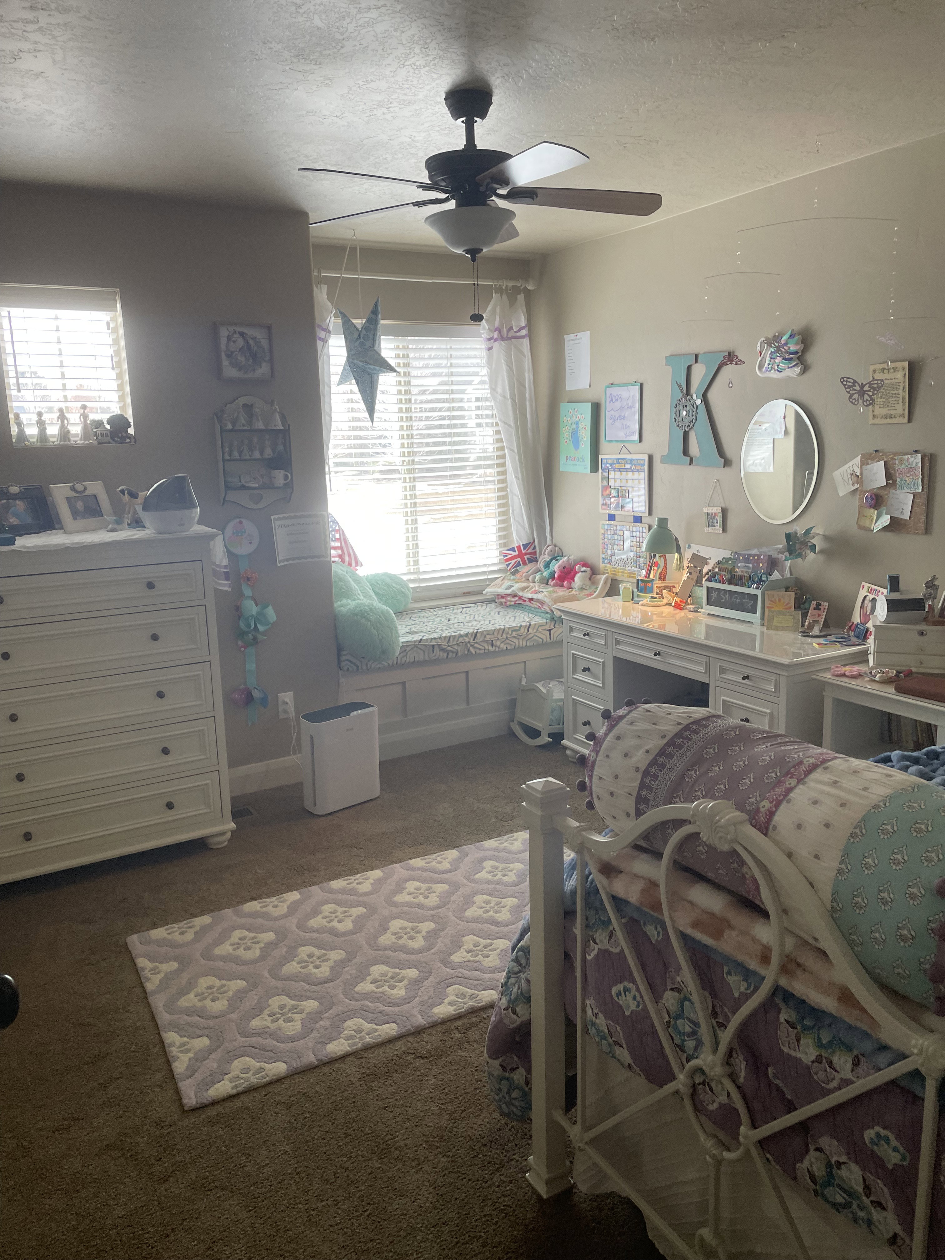 Integrated window seating with built-in storage, a ceiling fan with integrated lighting, and a window with horizontal blinds