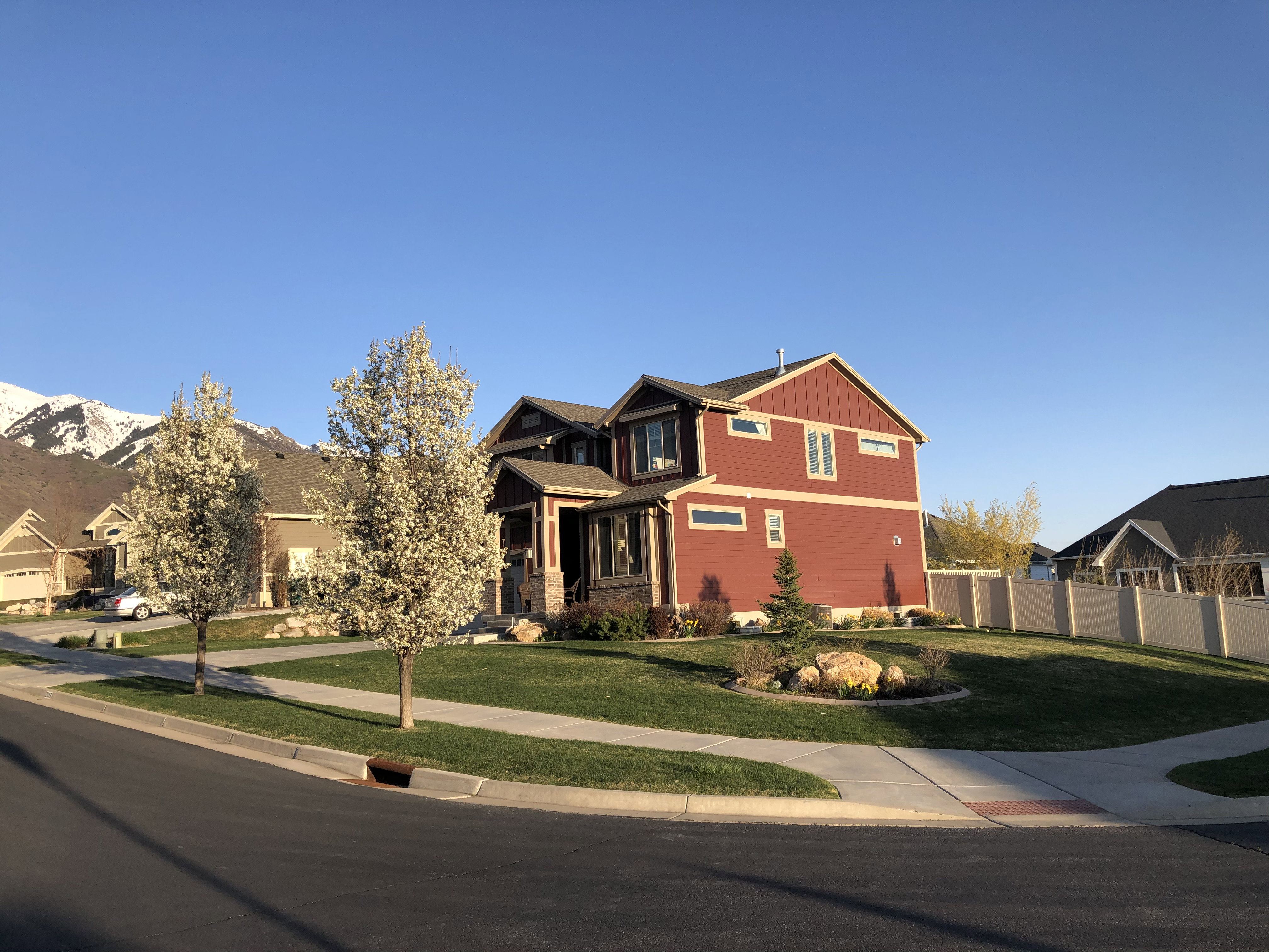 Two-story residence featuring red siding and stone accents