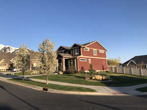 Two-story residence featuring red siding and stone accents