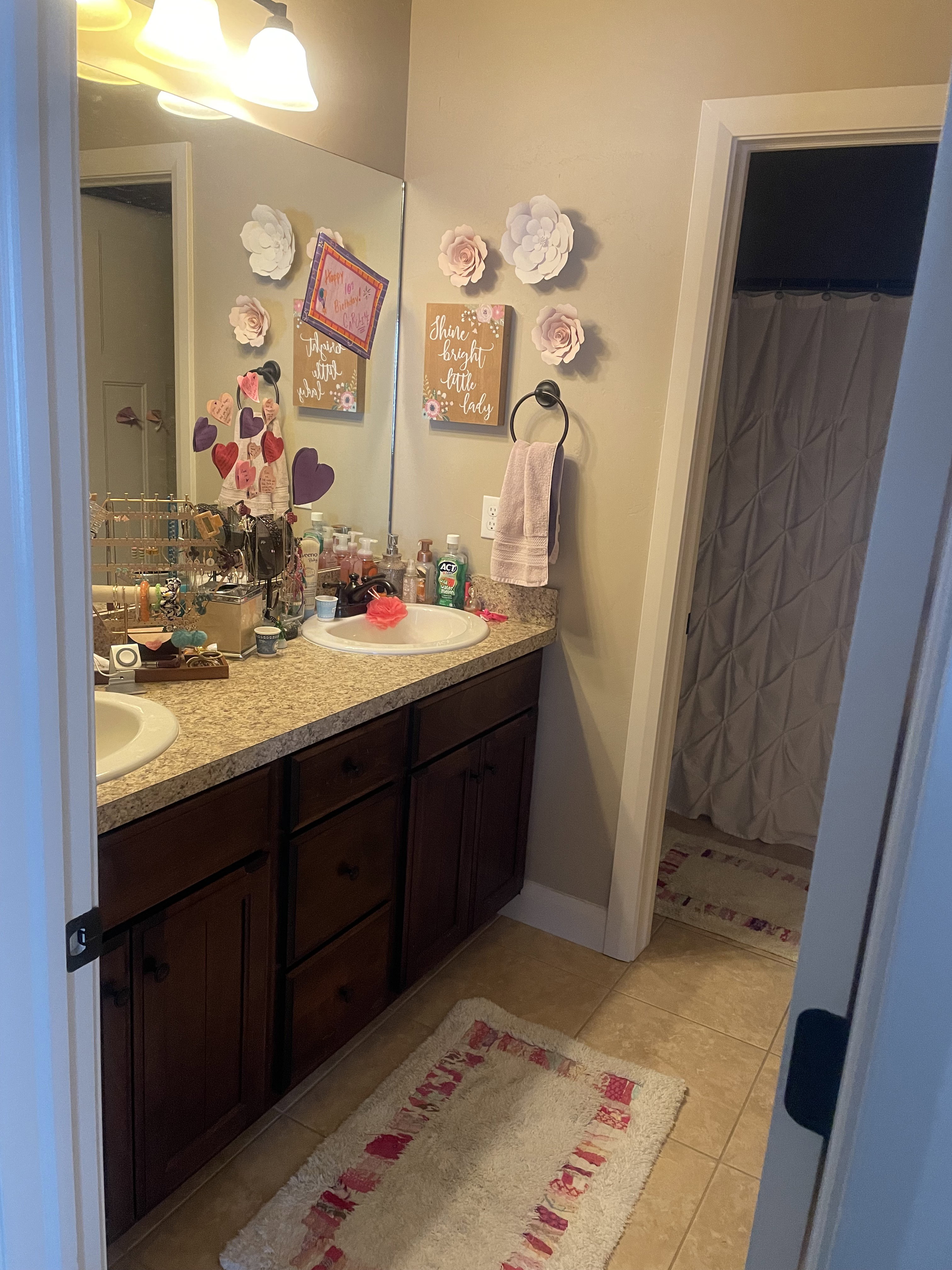 Bathroom featuring a dual vanity with undermount sinks, a speckled countertop, and dark wood cabinetry