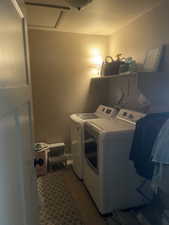 Laundry area featuring wood-finish flooring, a built-in overhead shelf, and a ceiling-mounted light fixture