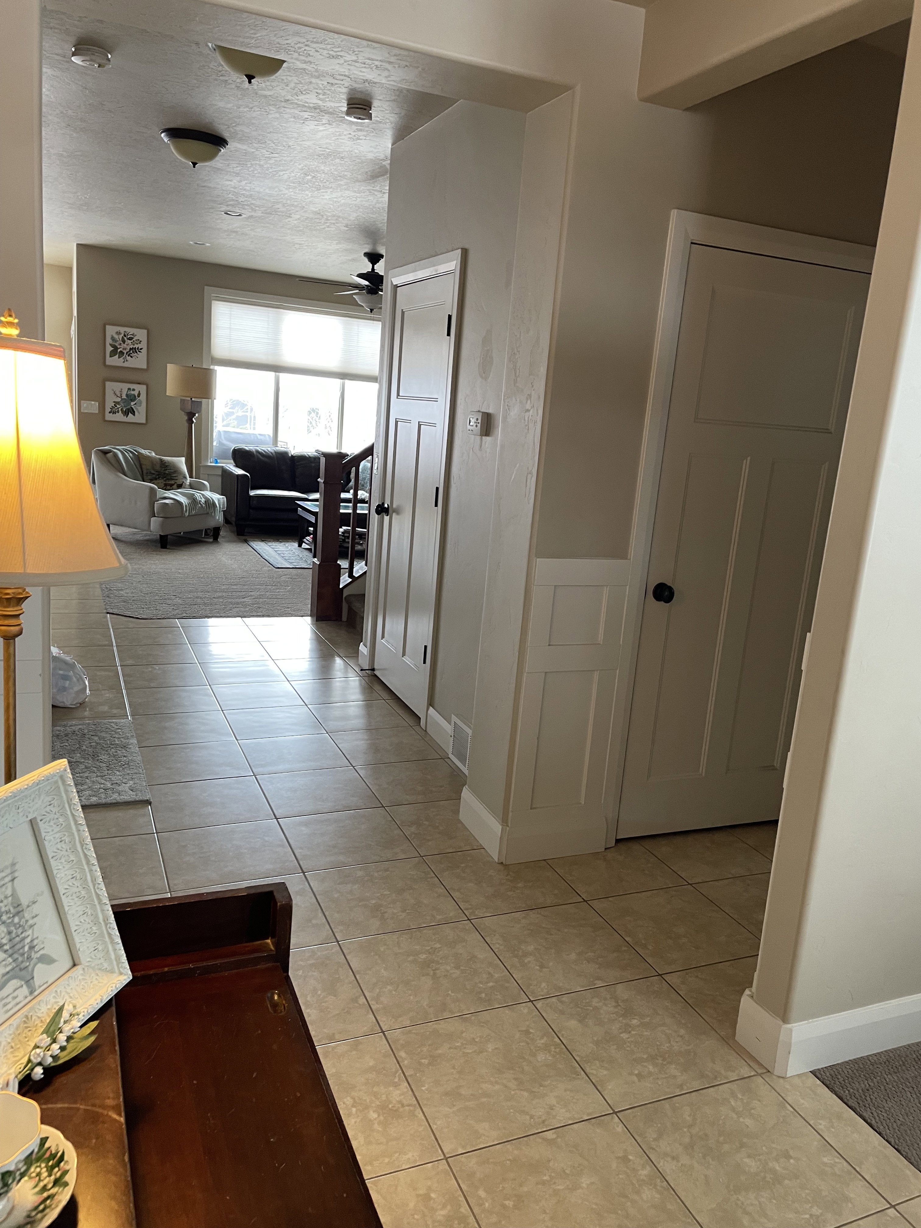 Tiled entryway featuring wainscoting and paneled doors