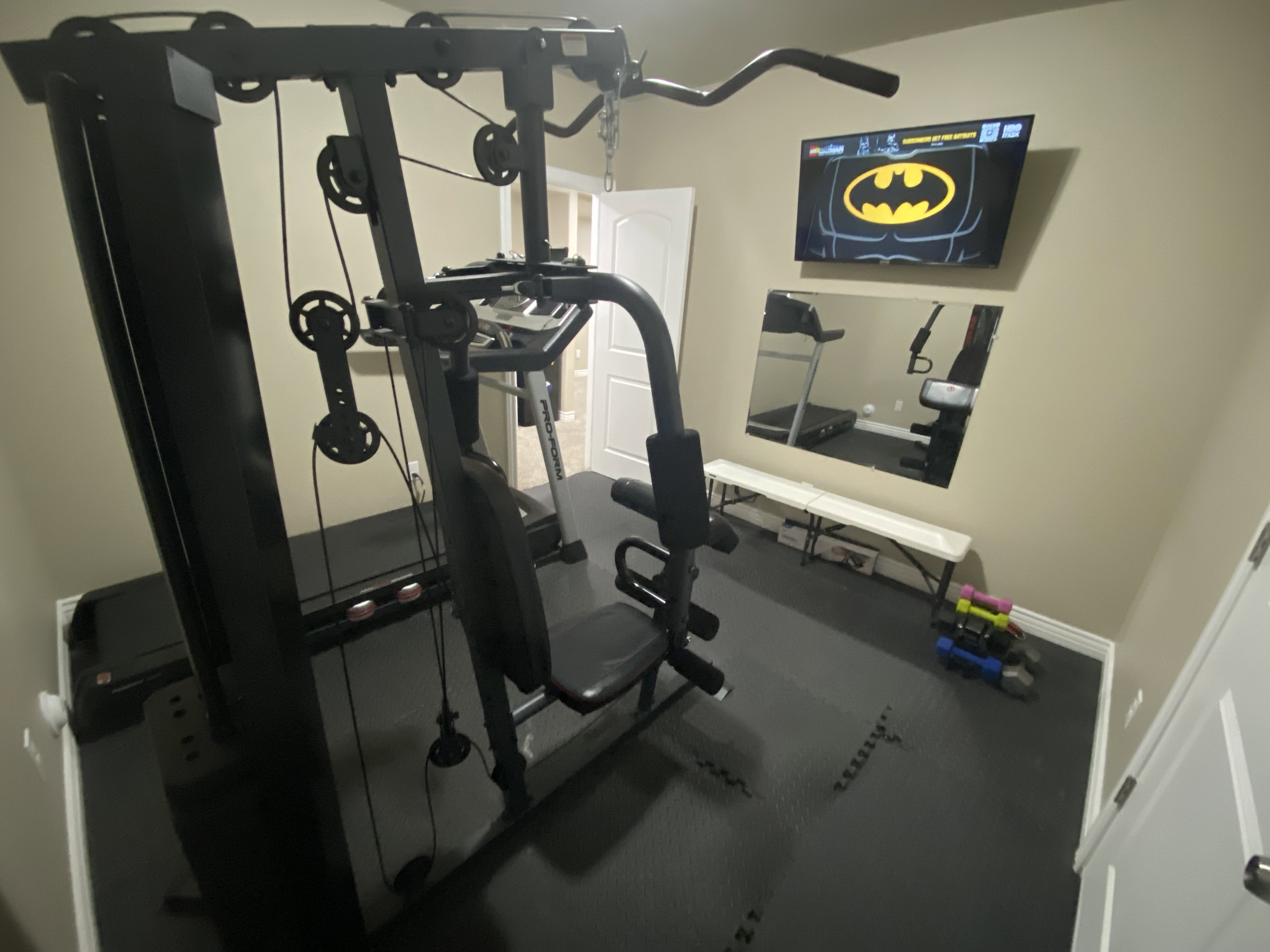 Dedicated room featuring interlocking rubber flooring, light beige wall paint, and white trim