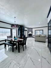 Spacious open-concept interior featuring large format marble-look tile flooring, a built-in fireplace with a mosaic tile surround, and recessed lighting