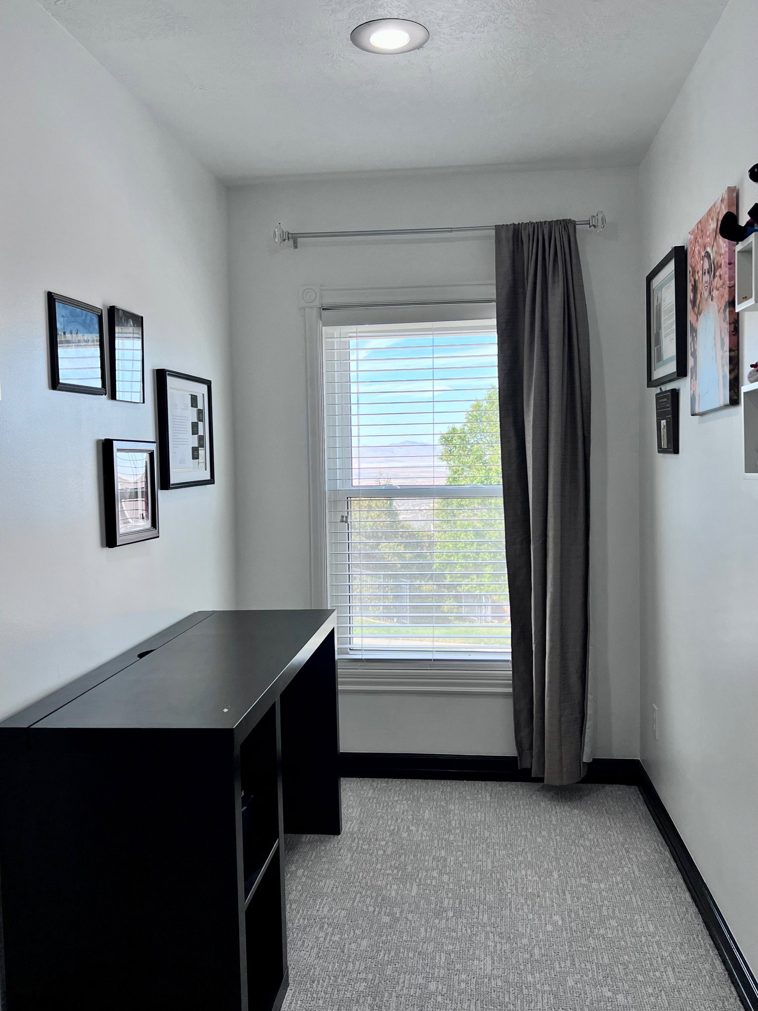 Compact interior space featuring a window with blinds, recessed ceiling lighting, and patterned flooring