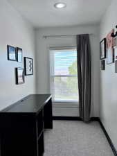 Compact interior space featuring a window with blinds, recessed ceiling lighting, and patterned flooring