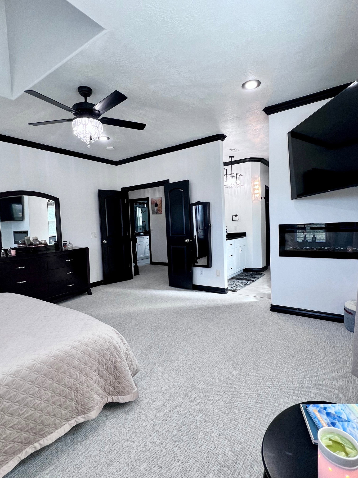 Spacious room with light-colored carpet flooring, black trim, and white walls
