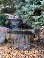Tiered rock waterfall feature surrounded by river stones