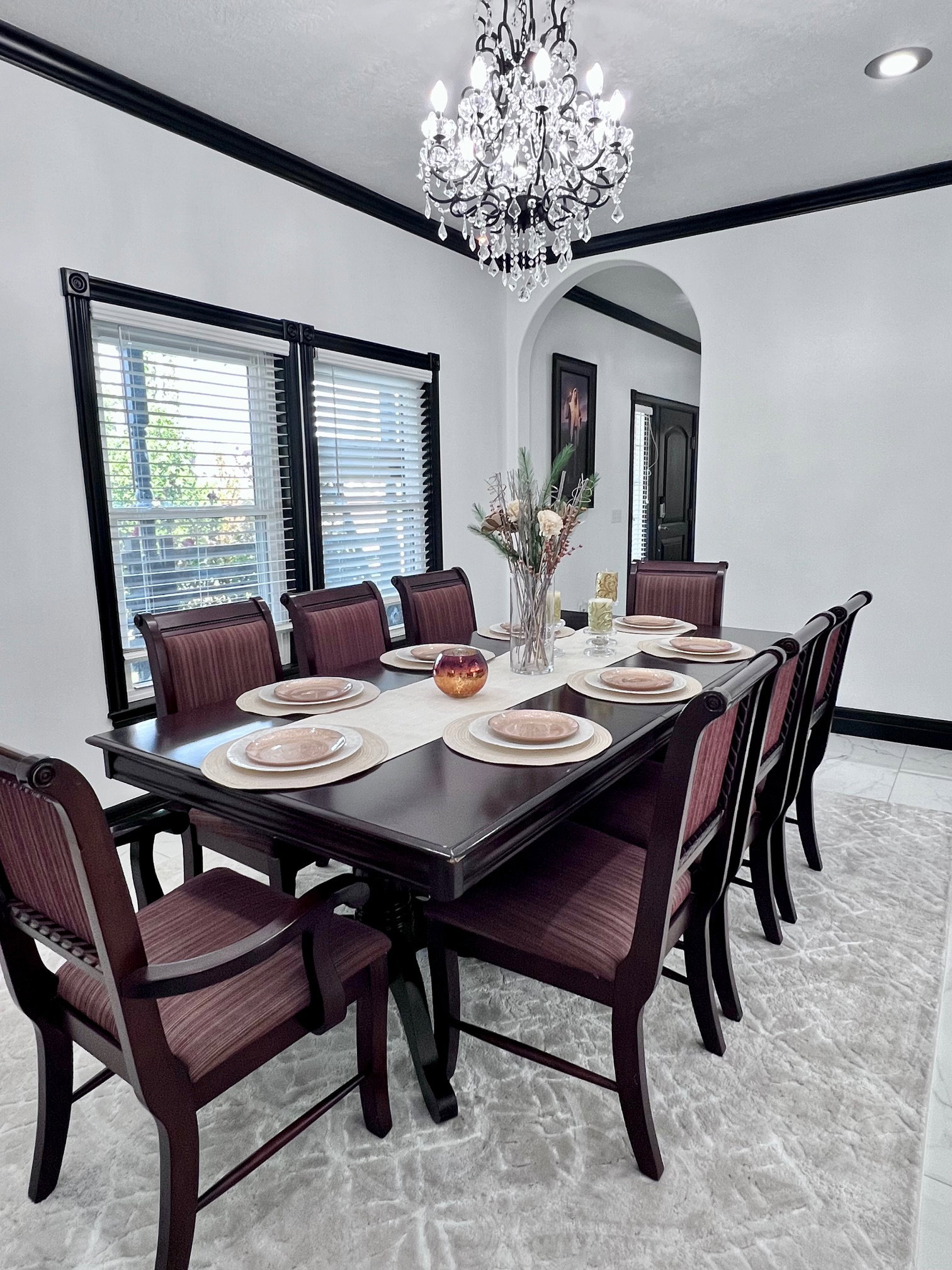 Formal dining area featuring a crystal chandelier and an arched entryway