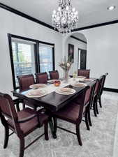 Formal dining area featuring a crystal chandelier and an arched entryway
