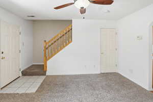 Foyer entry with tile flooring leading to a carpeted living space