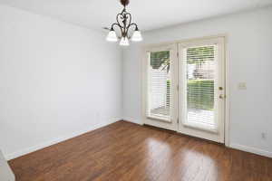 Wood-finish flooring throughout, featuring a double French door entry with integrated blinds