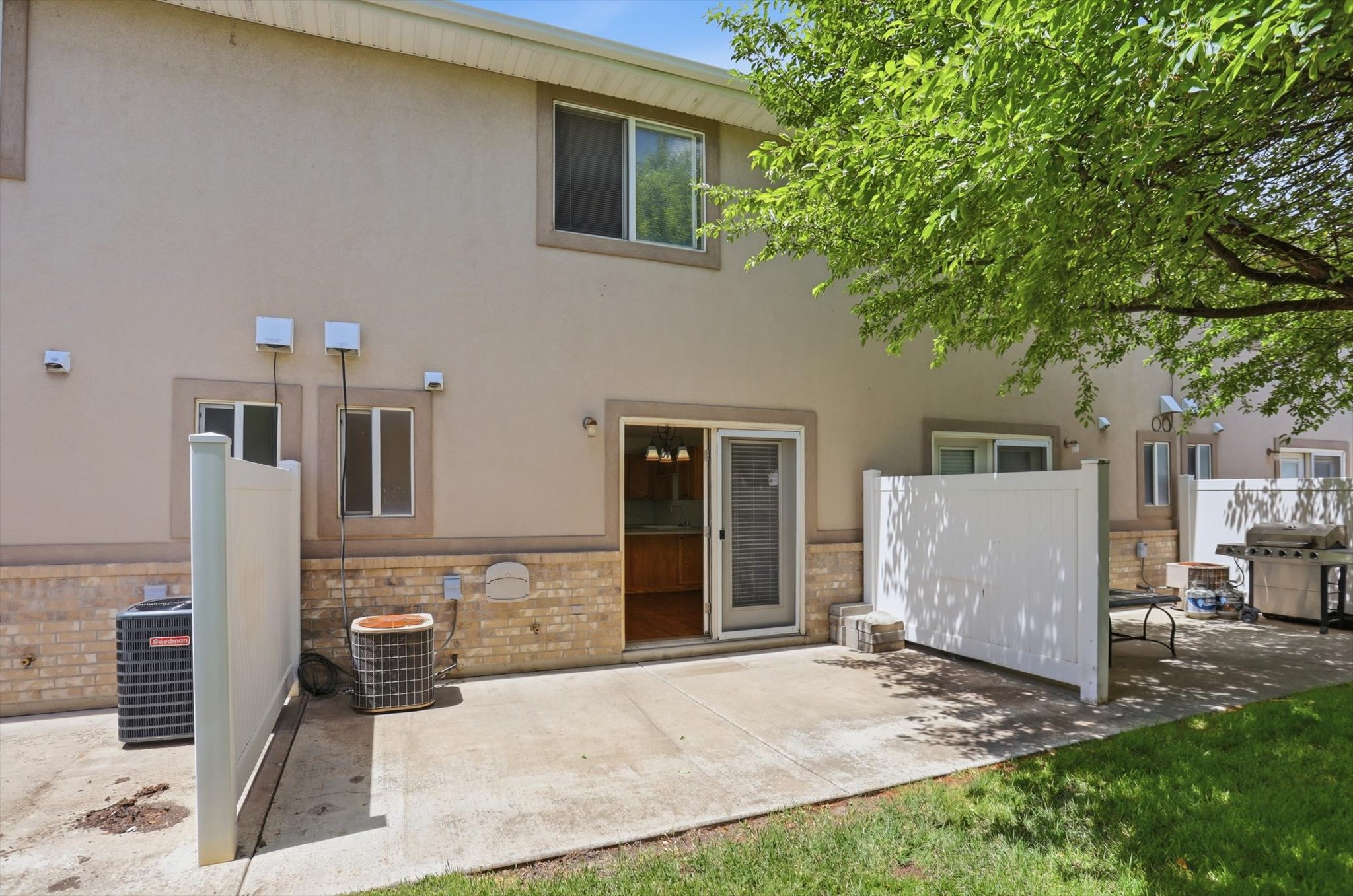 Rear exterior with a concrete patio, sliding glass door entry, and partial privacy fencing