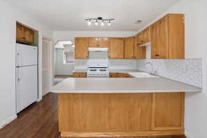 Kitchen featuring wood-finish cabinetry, white countertops, and hexagonal tile backsplash
