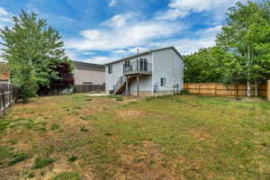 Spacious backyard featuring a newly built Trex l deck with stairs, a concrete patio area, and fully enclosed back yard with 6 foot high wood panel fencing
