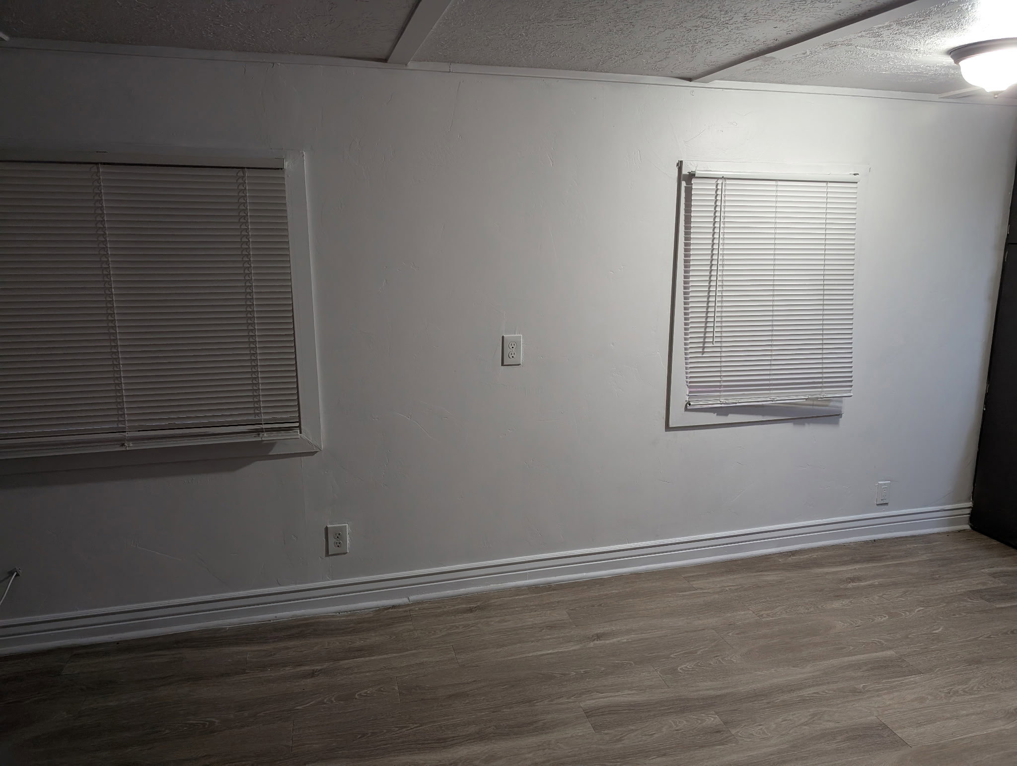 Interior room featuring wood-finish flooring and white walls