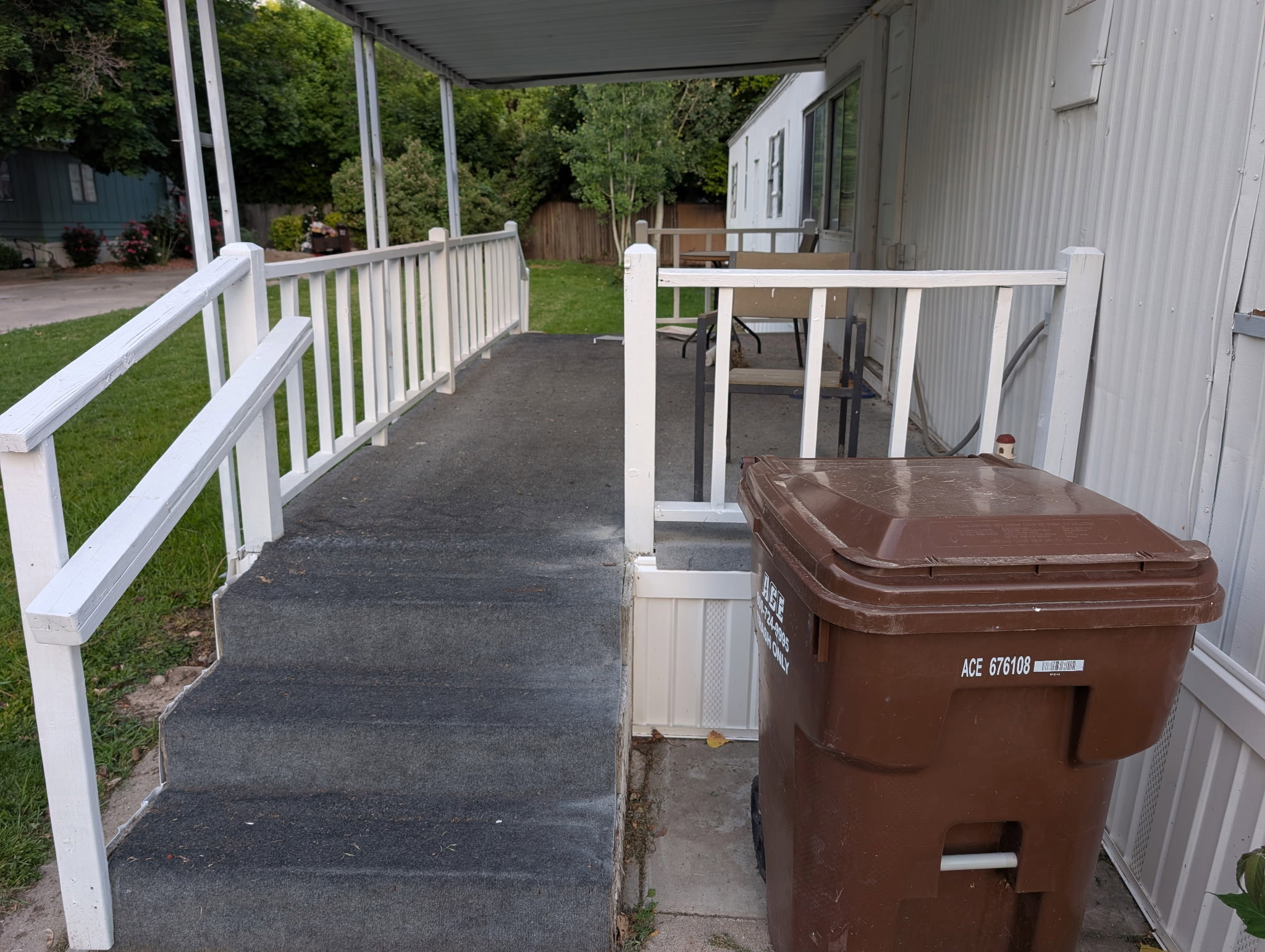 Entry porch with white railings and a gray-textured surface