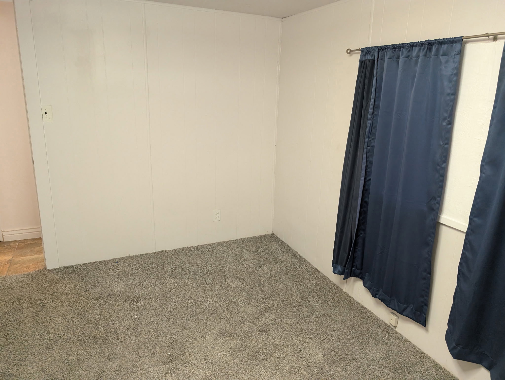 Plush gray carpeting throughout, complemented by white wall paneling
