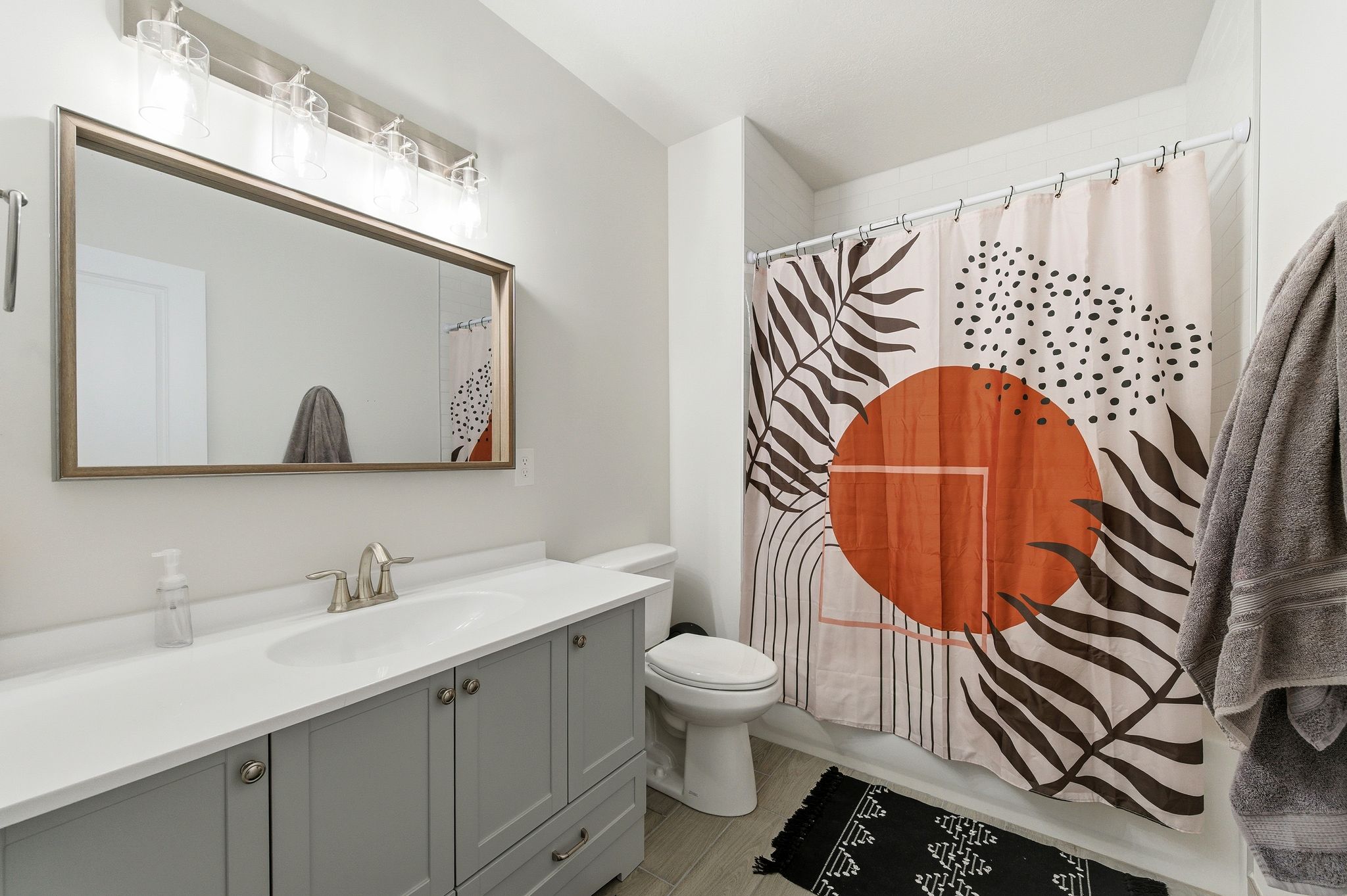 Bathroom featuring a single vanity with a gray cabinet, white countertop, and an undermount sink