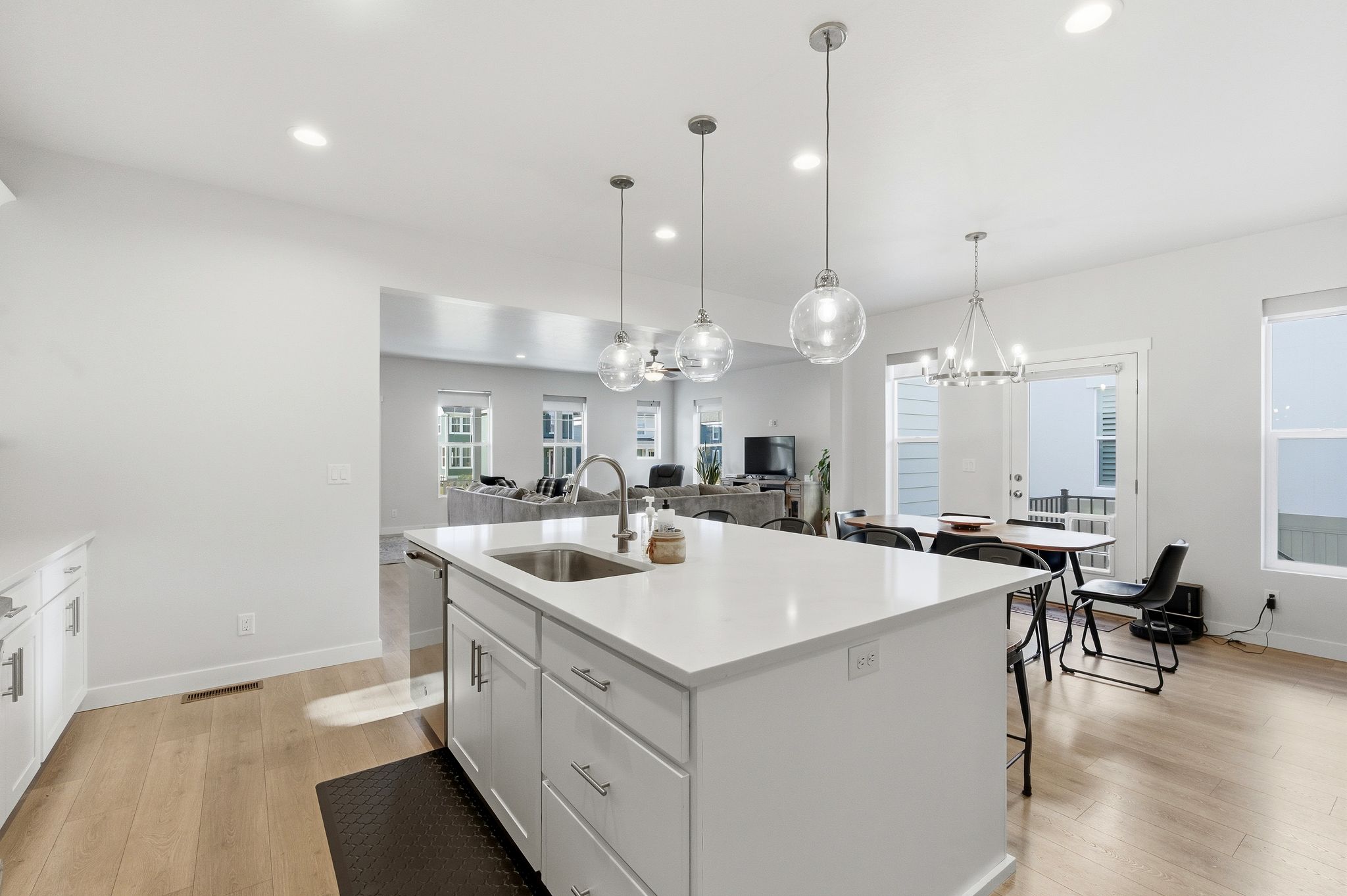 Spacious kitchen island with a stainless steel sink and modern pendant lighting