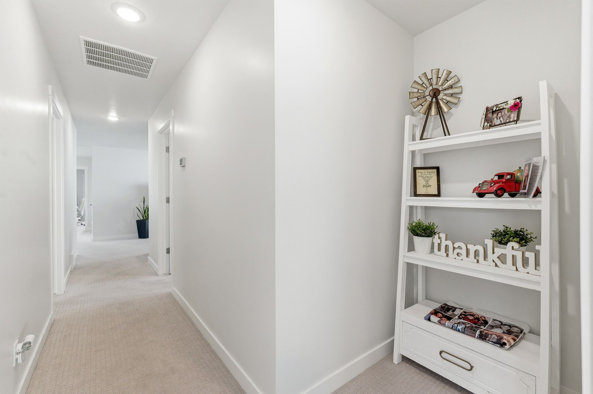 Hallway featuring recessed lighting, light neutral-toned carpeting, white walls, and white trim