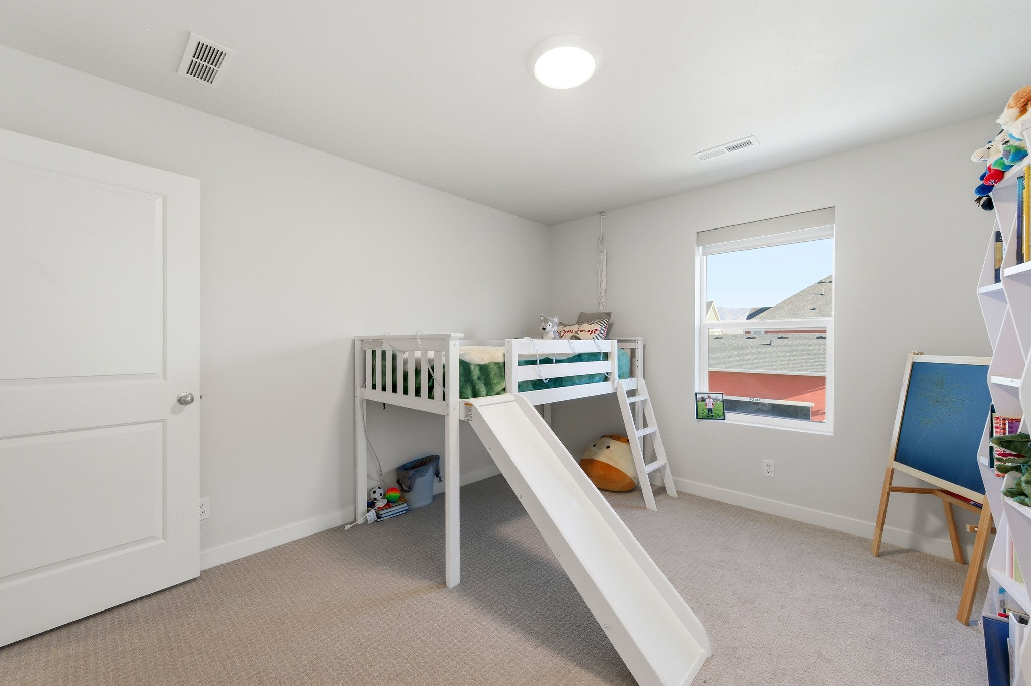 Carpeted room featuring light gray walls, a single window, white trim, and a flush-mount ceiling light fixture
